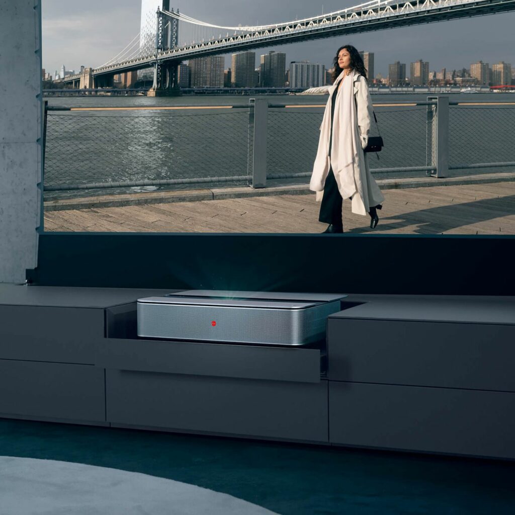 Kettnaker SOMA Media Lowboard mit Leinwand und Leica Projektor zeigt Frau in New York