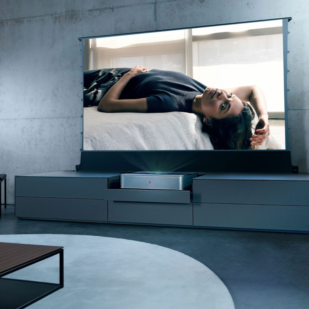 Kettnaker SOMA Media Lowboard mit Leinwand und Leica Projektor mit Couchtisch auf Teppich